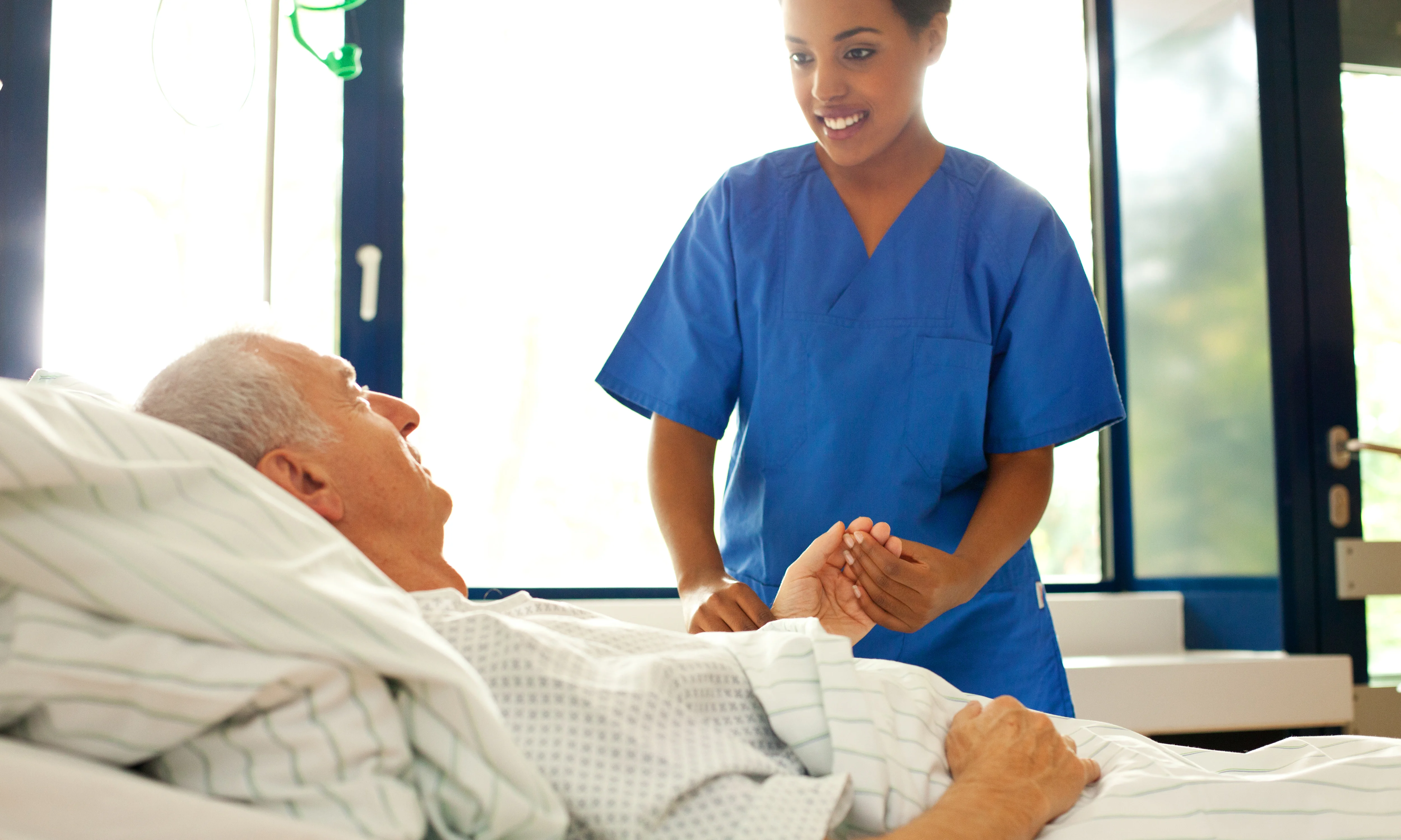 a woman standing over a man in a hospital bed